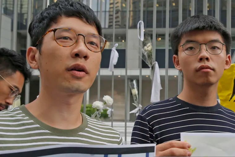 Pro-democracy activists Nathan Law (left) and  Joshua Wong speak to the media outside the government office in Hong Kong in June 2019.