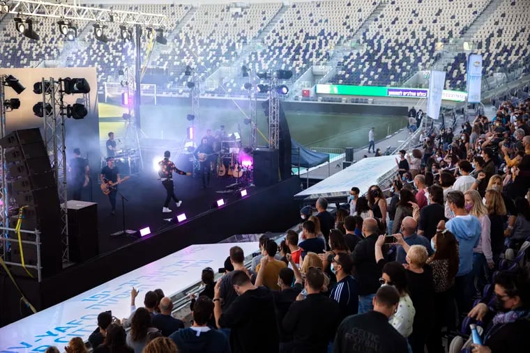 Israeli musician Ivri Lider performs in front of an audience at a soccer stadium in Tel Aviv where all guests were required to show "green passport" proof of receiving a COVID-19 vaccination or full recovery from the virus.