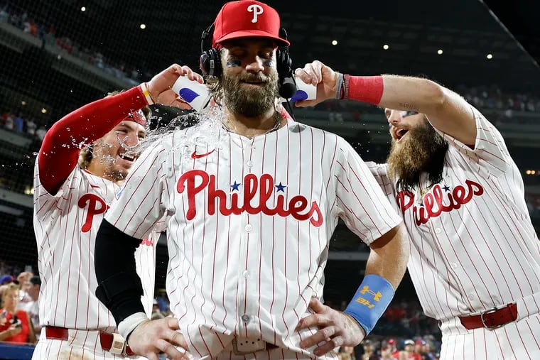 Brandon Marsh and Bryson Stott splash Bryce Harper after he delivered hit the game winning extra inning single to beat the Astros.