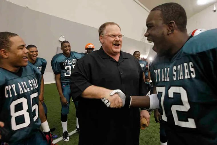 Eagles coach Andy Reid shakes hands with Dajuan Franks, a lineman from Frankford.