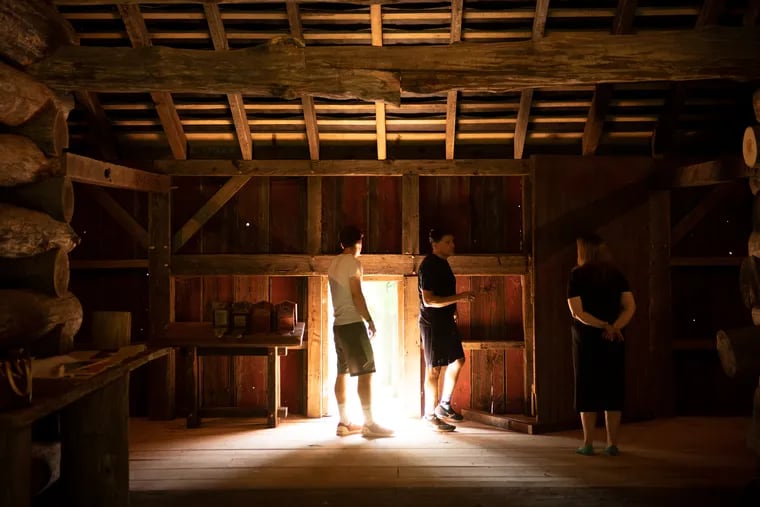 The original Jones Log Barn was two stories and built into an embankment. In the top level of the restored version, Steve Miller (center), who designed the exhibits, speaks with Pattye Benson (right), president of the Tredyffrin Historic Preservation Trust.
