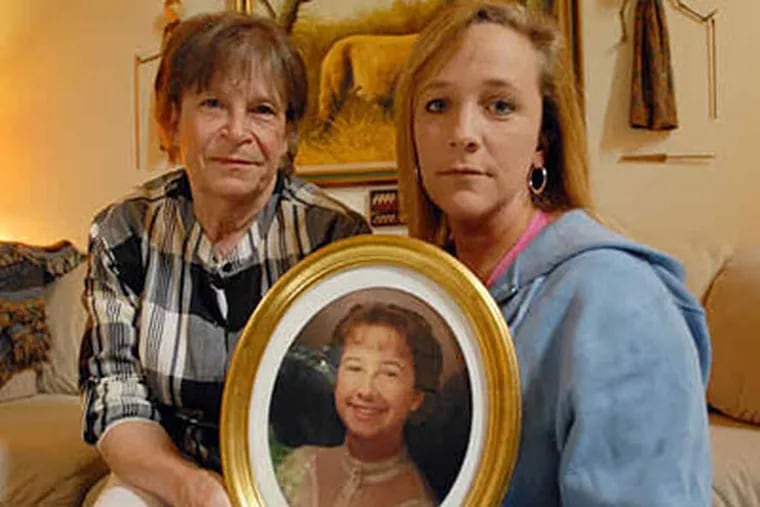 For Diane Mozino to move forward, she says, she needs to find her daughter Dawn and to give her a proper burial. She and daughter Cathy Mozino-Miesen hold a portrait of Dawn Mozino.