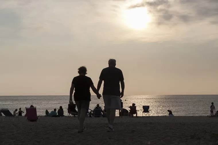 A couple strolls on the sand at Sunset Beach in Cape May Point, N.J.