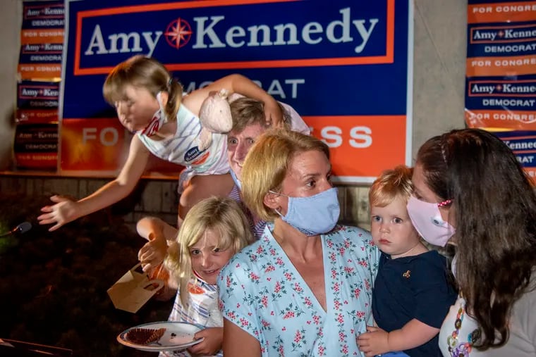 Amy Kennedy greets supporters after declaring victory in New Jersey’s 2nd Congressional District Democratic primary in Northfield on Tuesday. She holds her 2 year-old son Marshall as her husband, former U.S. Rep. Patrick Kennedy holds daughter Nellie, 4, behind her.