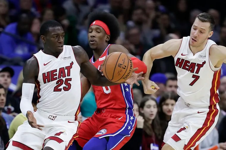 Sixers guard Josh Richardson attempts the steal the basketball against Miami Heat guard Kendrick Nunn and past Miami Heat guard Goran Dragic (right) during the first-quarter on Saturday, November 23, 2019 in Philadelphia.  Richardson fouled Nunn on the play.