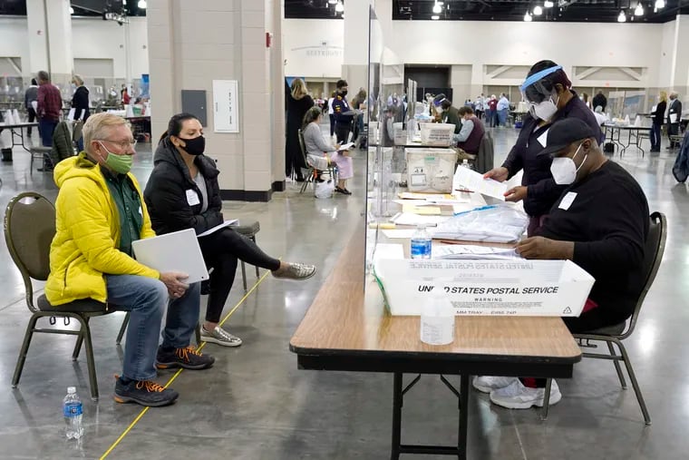 Election workers, right, verify ballots as recount observers, left, watch during a Milwaukee hand recount of presidential votes at the Wisconsin Center in Milwaukee in November.