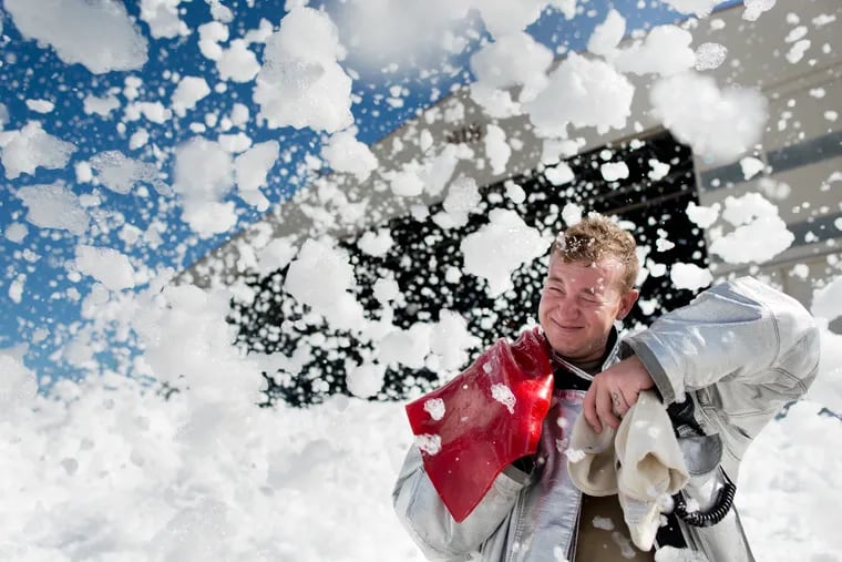 John Sherman, a 60th Engineer Squadron firefighter, is hit by fire-retardant foam in an aircraft hangar at Travis Air Force Base in California on Sept. 24, 2013. Firefighters with the 60th Air Mobility Wing helped control the foam’s dispersion using powerful fans and covering drains.