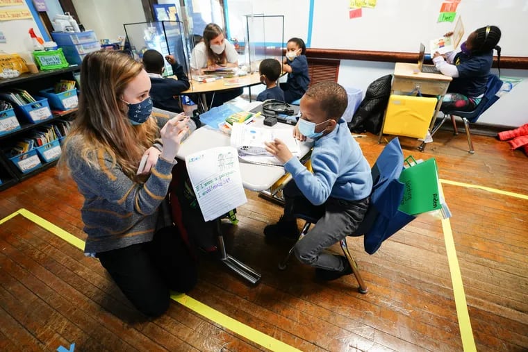 Student teacher Sophia Bonavolonta, left, works with student Aiden Moore at Belmont Charter School in February. Teachers are in Pennsylvania are now being vaccinated.