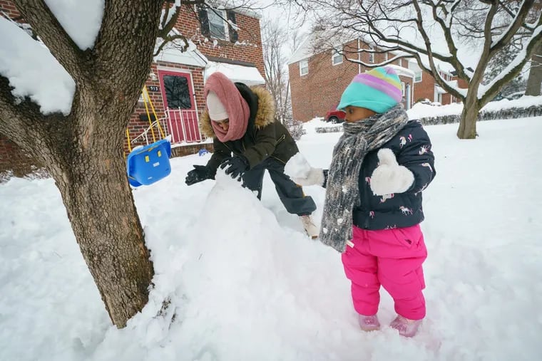 Latinya Jones, and her daughter Lailah build a snowman in Norristown on Tuesday.