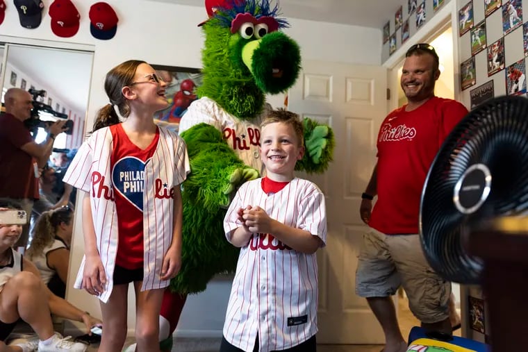 Rowan Linder, 5, reacts to his room makeover, as his sister Aubrey, left, the Phillie Phanatic and his dad Gary, right, stand nearby at his home in Langhorne, Pa. on Thursday.