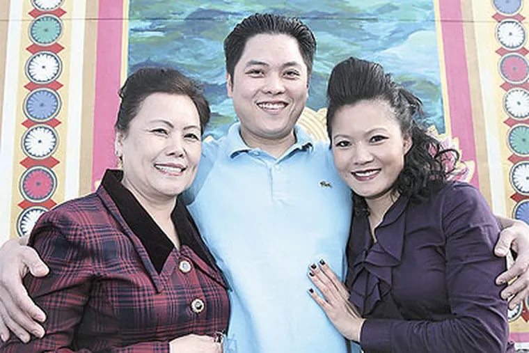 At the exhibit on Vietnamese refugees at the Asian Arts Initiative are (from left) Hien Cao with son Michael Quang Vo and daughter Kim Vo. (Steven M. Falk / Staff Photographer)