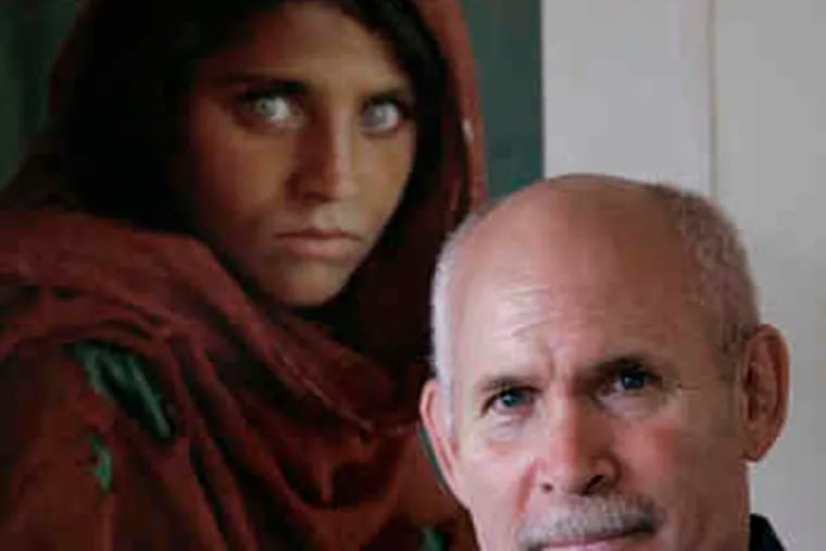 Steve McCurry stands in front of his famous print of an Afghan girl, showcasing Kodachrome's ability to capture vibrant yet realistic color. Kodak ended production of Kodachrome film in 2009.