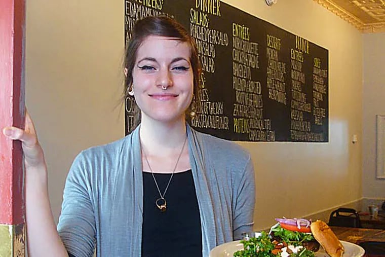 Vegan Commissary server Nina Ottaunick holds a Commissary Burger with Kale Salad. The eatery opens on Friday, Dec. 27. (Photo: Vance Lehmkuhl / Staff)