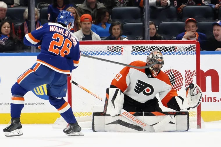 ELMONT, NEW YORK - NOVEMBER 25: Samuel Ersson #33 of the Philadelphia Flyers stops Oliver Wahlstrom #26 of the New York Islanders in the shootout at UBS Arena on November 25, 2023 in Elmont, New York. The Flyers defeated the Islanders 1-0 in the shootout.  (Photo by Bruce Bennett/Getty Images)