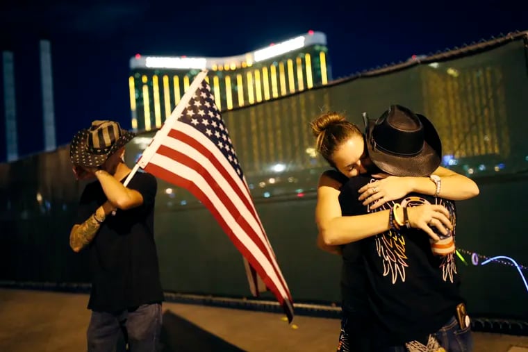 Megan Murphy, right in hat, embraces Cara Knoedler as Kenneth Wright wipes his eyes on the first anniversary of the Oct. 1 mass shooting in Las Vegas. The Trump administration has failed to move on gun safety even in the wake of the carnage that claimed 58 lives.