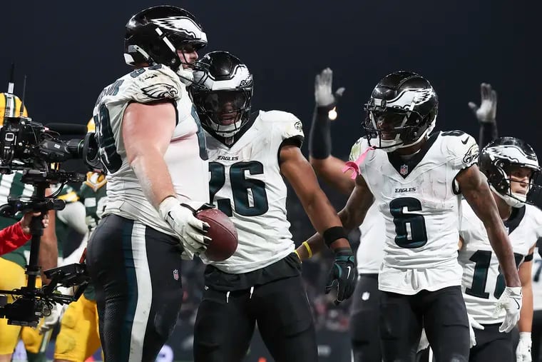 Eagles running back Saquon Barkley celebrates his third-quarter touchdown run with teammates guard Landon Dickerson (left) and wide receiver DeVonta Smith in the season opener against the Green Bay Packers at Corinthians Arena in São Paulo, Brazil.