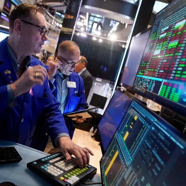 Specialist Patrick King, left, works at his post on the floor of the New York Stock Exchange on Tuesday, Aug. 6, 2024.