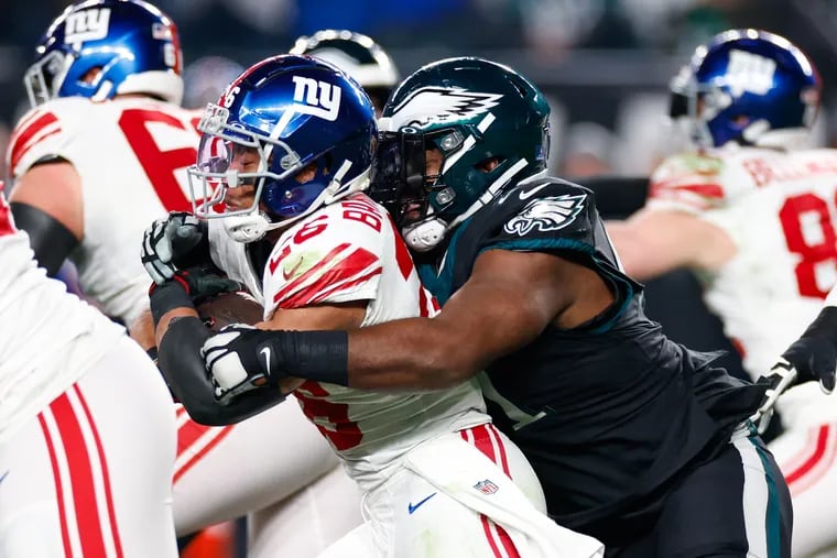 Giants running back Saquon Barkley gets wrapped up by the Eagles' Fletcher Cox on Dec. 25 at the Linc. Barkley has a much better line now.