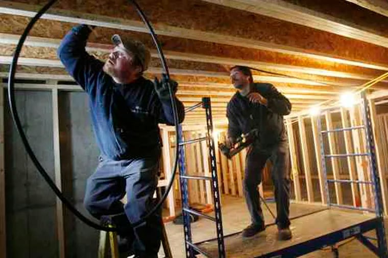 Construction boom? Jeff Rose (left) and Wayne Green of Gillespie Fuels install a heating system in Vermont. Improved weather in November helped new-home construction rebound.