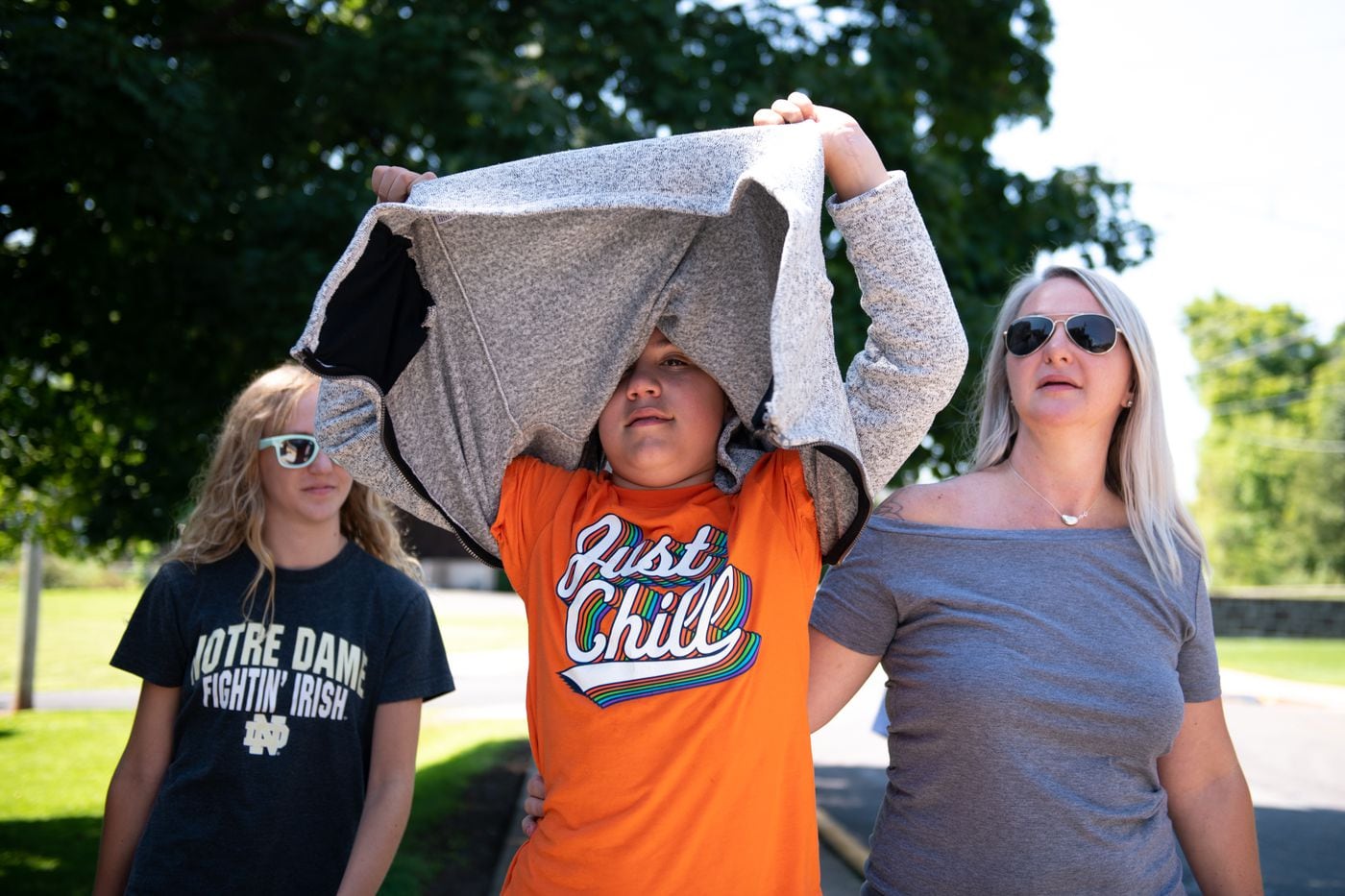 Ronan Strouse peeks out from under a sweater while on a walk with his mother, Celine Nace, and his sister Barron.