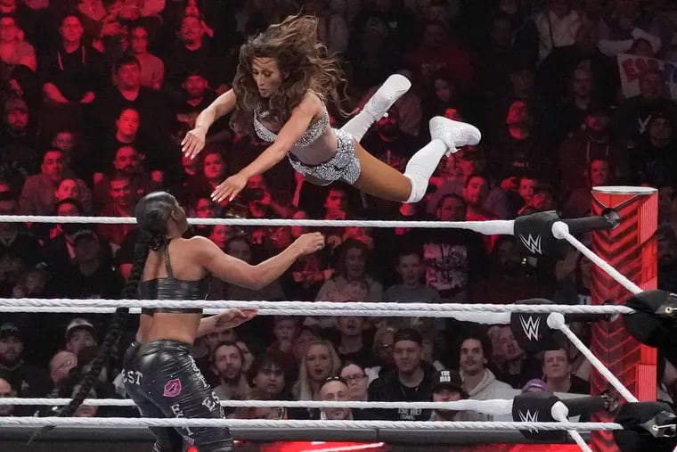 WWE's Carmella leaps at Bianca Belair during a "Monday Night RAW" match in March in Boston. Next spring, the wrestling world will descend on Philadelphia for WrestleMania 40.