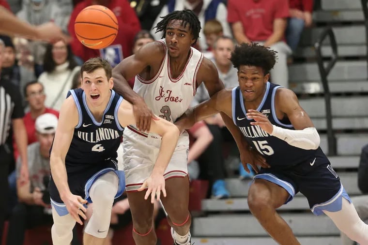 Chris Arcidiacono (left) and Jordan Longino (right) of Villanova battle Cameron Brown for a loose ball during the 2nd half of their game at Hagan Arena on Dec. 17, 2022.