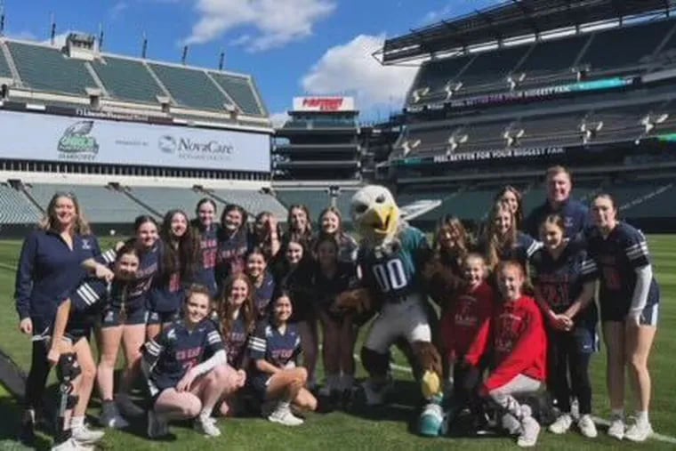 The Central Bucks East girls' flag football team poses with Swoop, the Eagles' mascot.