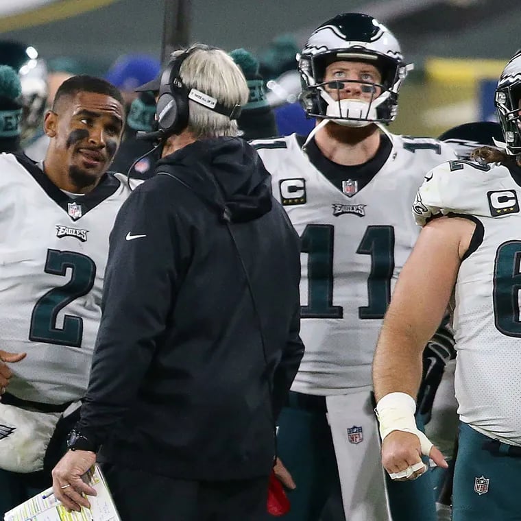 Jalen Hurts left, speaks with former coach Doug Pederson with benched starter Carson Wentz and Jason Kelce nearby during a 2020 Week 13 game in Green Bay -- the game that marked the end of Wentz's career with the Eagles.