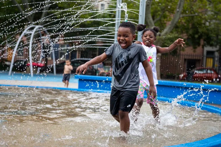 Dallas Ellis, 6, runs from his sister, Ra-lee Ellis, 8, while playing in the sprayground at Seger Park on Tuesday.