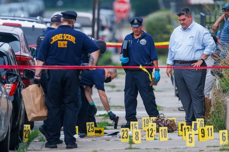 Crime scene officers at the site of a double homicide on the 6100 block of Locust Street in West Philadelphia Friday morning.