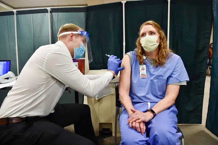 Julie Petre, an ICU pharmacist, receives the Pfizer COVID-19 vaccination at St. Peter's Health in Helena, Mont., in December. Medical providers and Montana residents with compromised immune systems are challenging the only law in the U.S. that prevents state employers from mandating workers get vaccinated.