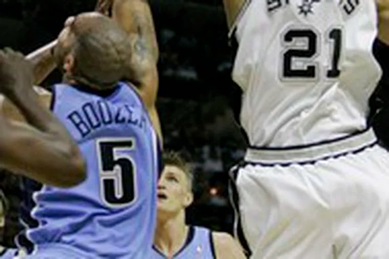 San Antonio&#0039;s Tim Duncan (right) swats a shot by Utah&#0039;s Carlos Boozer during the opening game of the Western Conference finals.The Spurs won, 108-100, yesterday. C3.