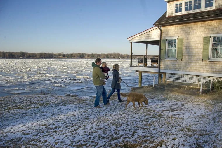 Peter and Kate Canton, with daughter Charlotte, 2 1/2, and Bay the Chesapeake Bay retriever take a walk outside their waterfront home on the Delaware River in Delanco.