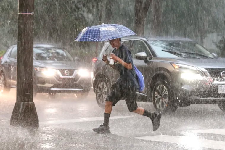 Rush hour downpour as a person crosses the street at 18th and Walnut on Thursday. A twister visited Delaware.