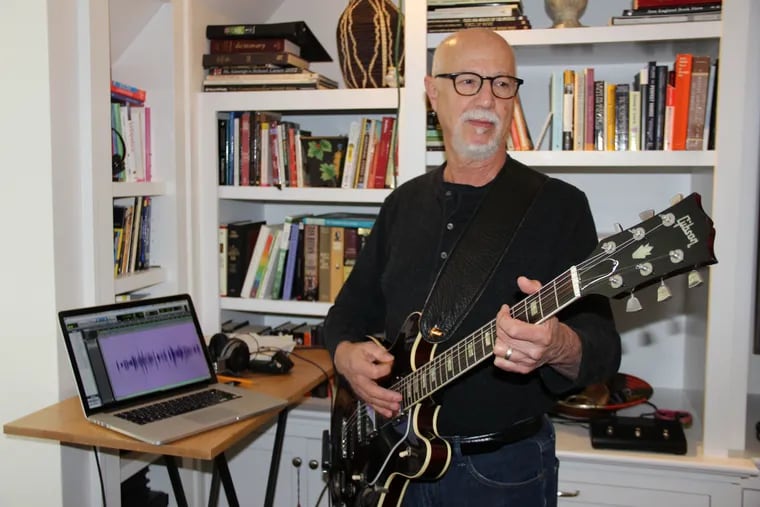 Frank Ingari plays guitar in his home studio.