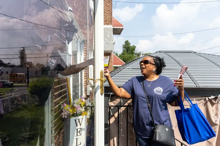 Tanya Gillespie-Lambert, of Cramer Hill, N.J., community and parent involvement specialist at Early Childhood Development Center, talks with a resident to encourage her or any families with kids to enroll them in preschool.