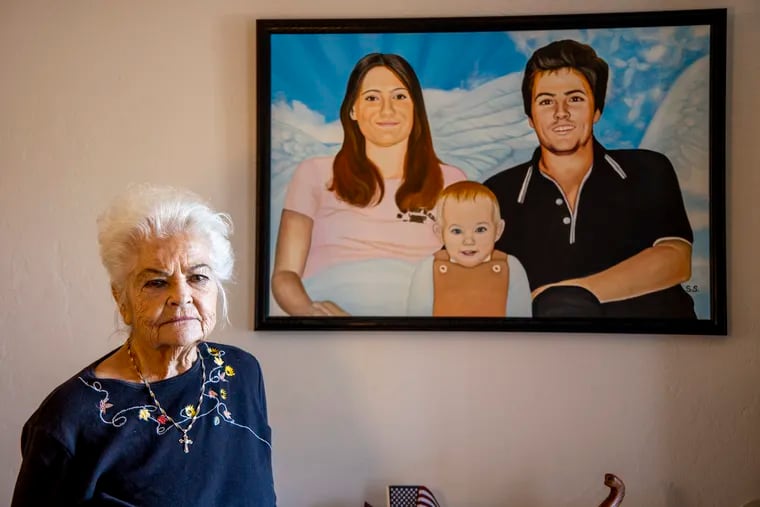 Donna Casasanta poses in front of a painting showing her late son, Harold Dean Clouse, with Clouse's wife, Tina Gail Linn, and their daughter, Hollie Marie Clouse, at Casasanta's Edgewater, Fla., home in January.