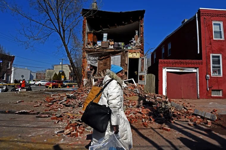 In March 2015, Alyce Ali walks past her Camden home after removing some belongings; the Line Street home had partially collapsed the night before.