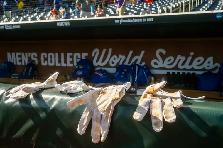 Batting gloves are seen on the rail to the Florida Gators dugout prior to Game 3 of the NCAA College World Series baseball finals against the LSU Tigers at Charles Schwab Field on June 26, 2023 in Omaha, Nebraska. (Photo by Jay Biggerstaff/Getty Images)