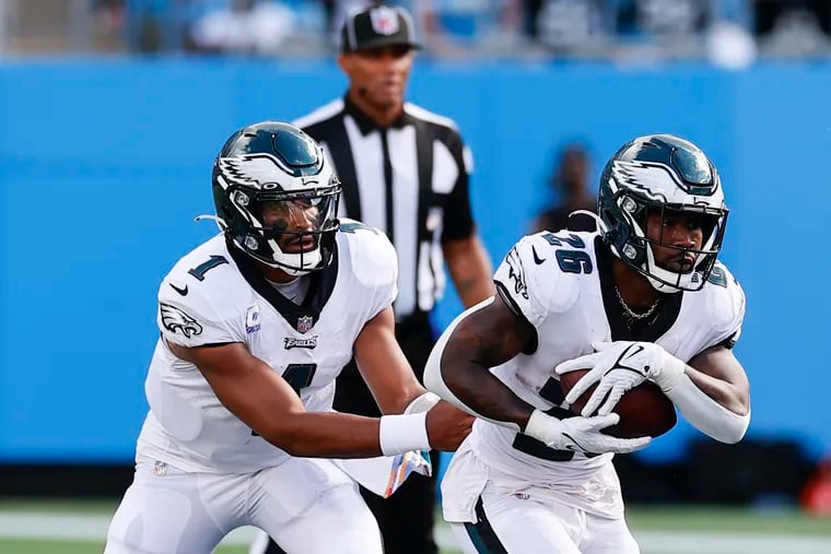 Eagles running back Miles Sanders takes the football from quarterback Jalen Hurts against the Carolina Panthers on Sunday in Charlotte.