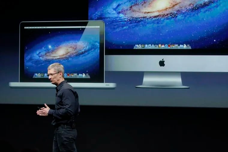 FILE - In this Tuesday, Oct. 4, 2011, file photo, Apple CEO Tim Cook  speaks in front of a projection of the Macbook Air and Mac Desktop during announcement at Apple headquarters in Cupertino, Calif. Apple CEO Tim Cook said Thursday the company will produce one of its existing lines of Mac computers in the United States next year. Like most consumer electronics companies, Apple forges agreements with contract manufacturers to assemble its products overseas.  (AP Photo/Paul Sakuma, File)