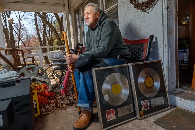 Lenny Pakula, a former keyboards player with Philadelphia International Records, sits on the porch of his Feasterville home, displaying two framed platinum albums that he played on, one with Teddy Pendergrass, the other with the O’Jays. He lives in poverty and has suffered from hunger and malnutrition.