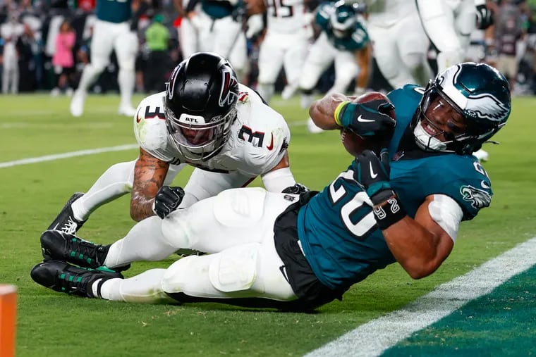 Eagles running back Saquon Barkley gets a first down past Falcons safety Jessie Bates III in the fourth quarter.