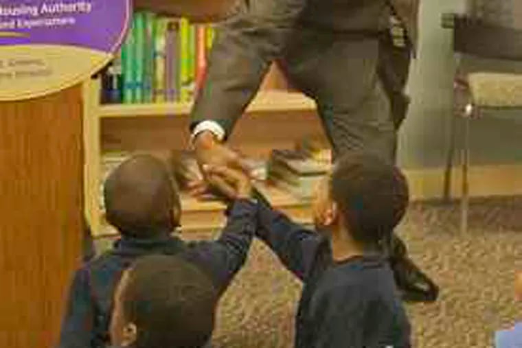 City Councilman Darrell Clarke greets youngsters , above, at the Housing Authority&#0039;s new library inside the John F. Street Community Center at 11th and Poplar Streets. It will serve the families living in North Philadelphia&#0039;s Richard Allen and Cambridge housing developments. Above left, Kyarea Smith (left), 12, and Nasihah White, 11, at the ribbon-cutting.