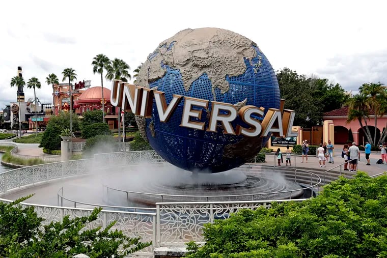 Guests cool off under a water mist by the globe at Universal Studios City Walk at Universal Studios Florida in Orlando, Fla. in 2019.