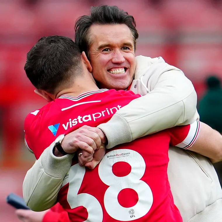 Wrexham Co-Owner Rob McElhenney, rear, and Elliot Lee of Wrexham celebrate after the English League Two soccer match between Wrexham and Stockport at the Racecourse Ground Stadium in Wrexham, Wales, Saturday, April 27, 2024. Wrexham AFC got promoted to League One.(AP Photo/Jon Super)