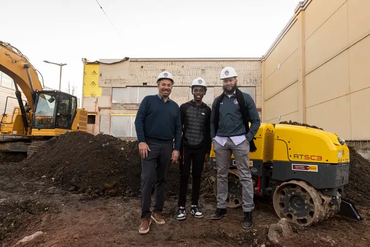 Kenny Holdsman, the center's cofounder and CEO, Youth Leadership Council member Kasim Wheeler, and chief mission officer Ameen Akbar outside of the construction site for the Philadelphia Youth Basketball Alan Horwitz “Sixth Man” Center in December. The 100,000-square-foot facility is located in Nicetown.