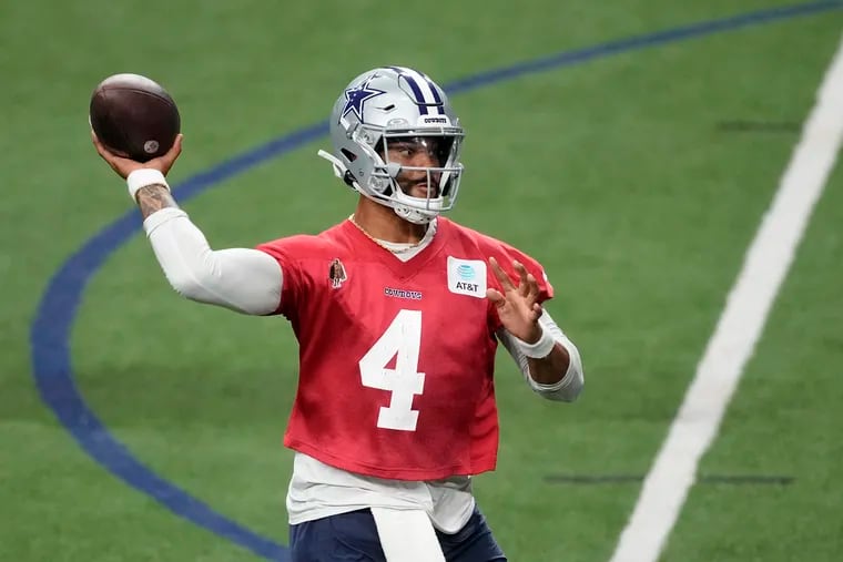 Dallas Cowboys quarterback Dak Prescott throwing a pass at the team's training facility.