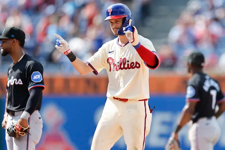 Phillies Trea Turner celebrates after hitting a two RBI single during the seventh inning past Marlins second base Otto Lopez (left).  Turner advanced to second on a Marlins error.