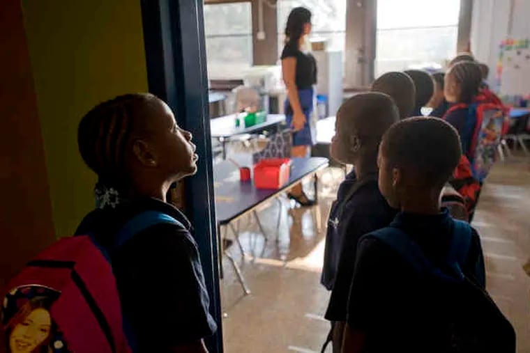 Iyanna Clark and her first-grade classmates wait to be checked in to Katie Harbaugh's class at Harrity, taken over by Mastery Charter Schools.